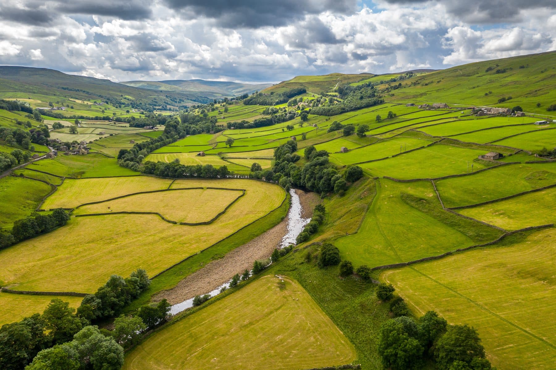 A green river valley winding through the countryside